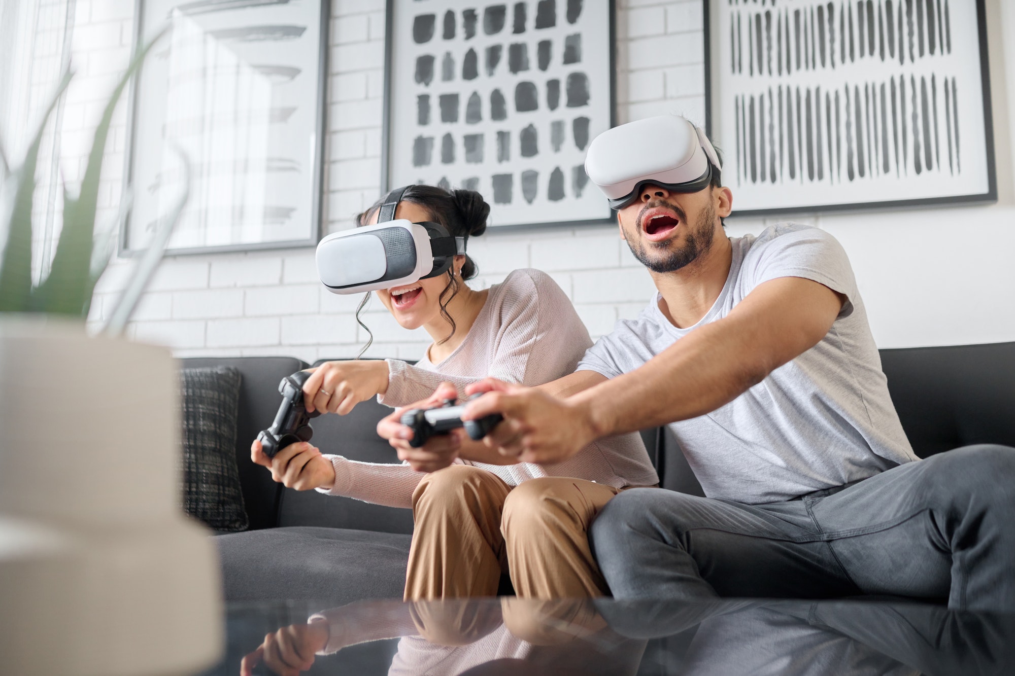 Virtual reality, gaming and metaverse with a couple playing video games in their home together for